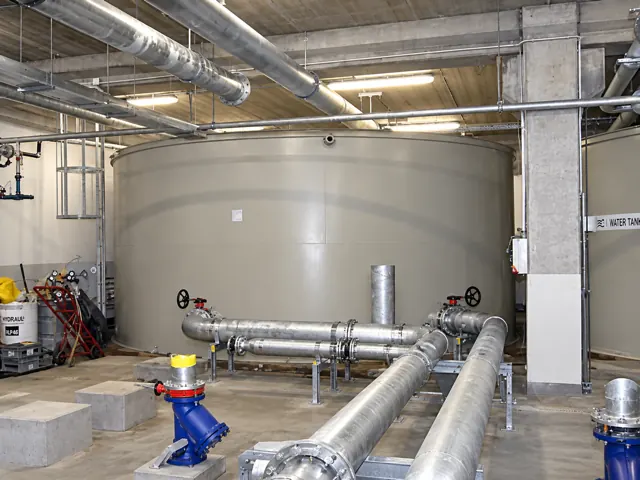 Veľká valcová plastová chladiaca nádrž v technickej hale s napojeným nerezovým potrubím a ventilmi